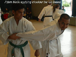 Adam Malik applying shoulder bar on Saeed.