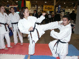 Dorothy Yu executes a side kick to Mohamed Fizali's head while Lisa Siroki and Tonija Skuja look on during Queen's visit.